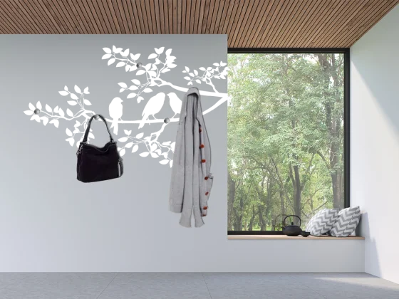 Ast mit Vögeln als dekorative Wandgarderobe im Hausgang