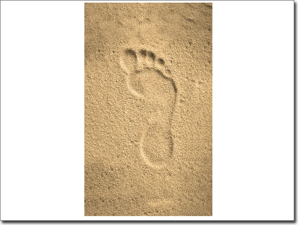 Digitaldruck auf Glas mit einem Fußabdruck im Sand in sepia