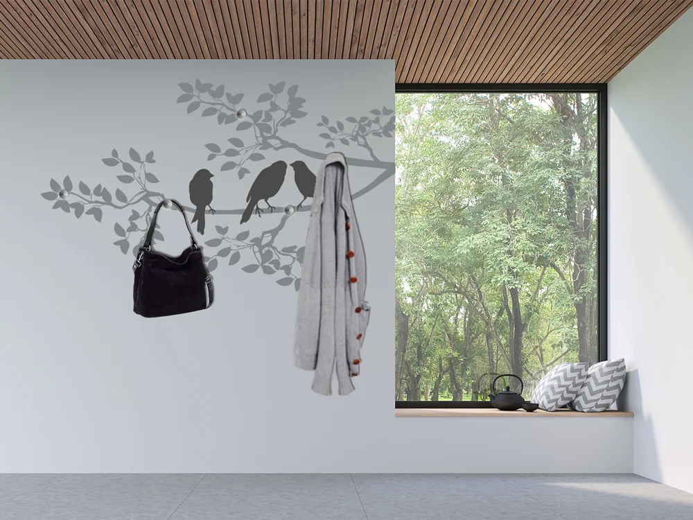Ast mit Vögeln als dekorative Wandgarderobe im Eingang